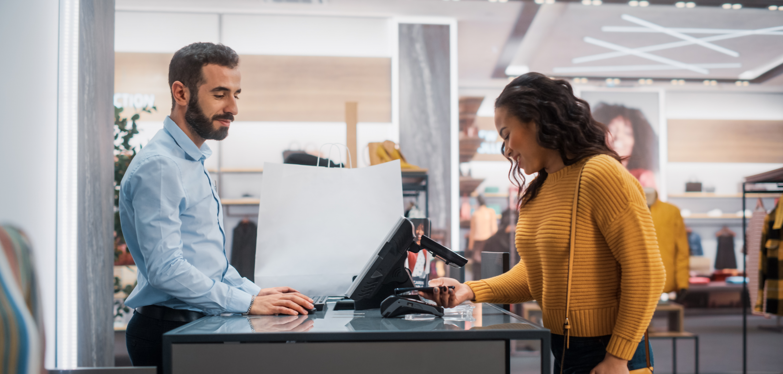 Customer completing a contactless payment at a retail store counter, highlighting seamless and secure retail experiences.
