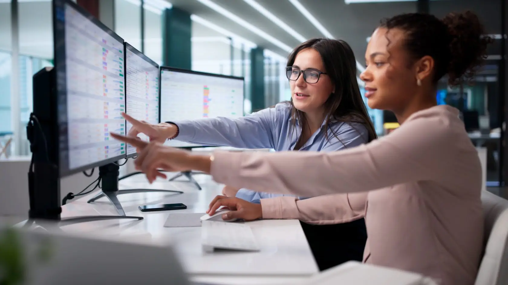 Team collaborating while analyzing AI data dashboards on a large monitor.