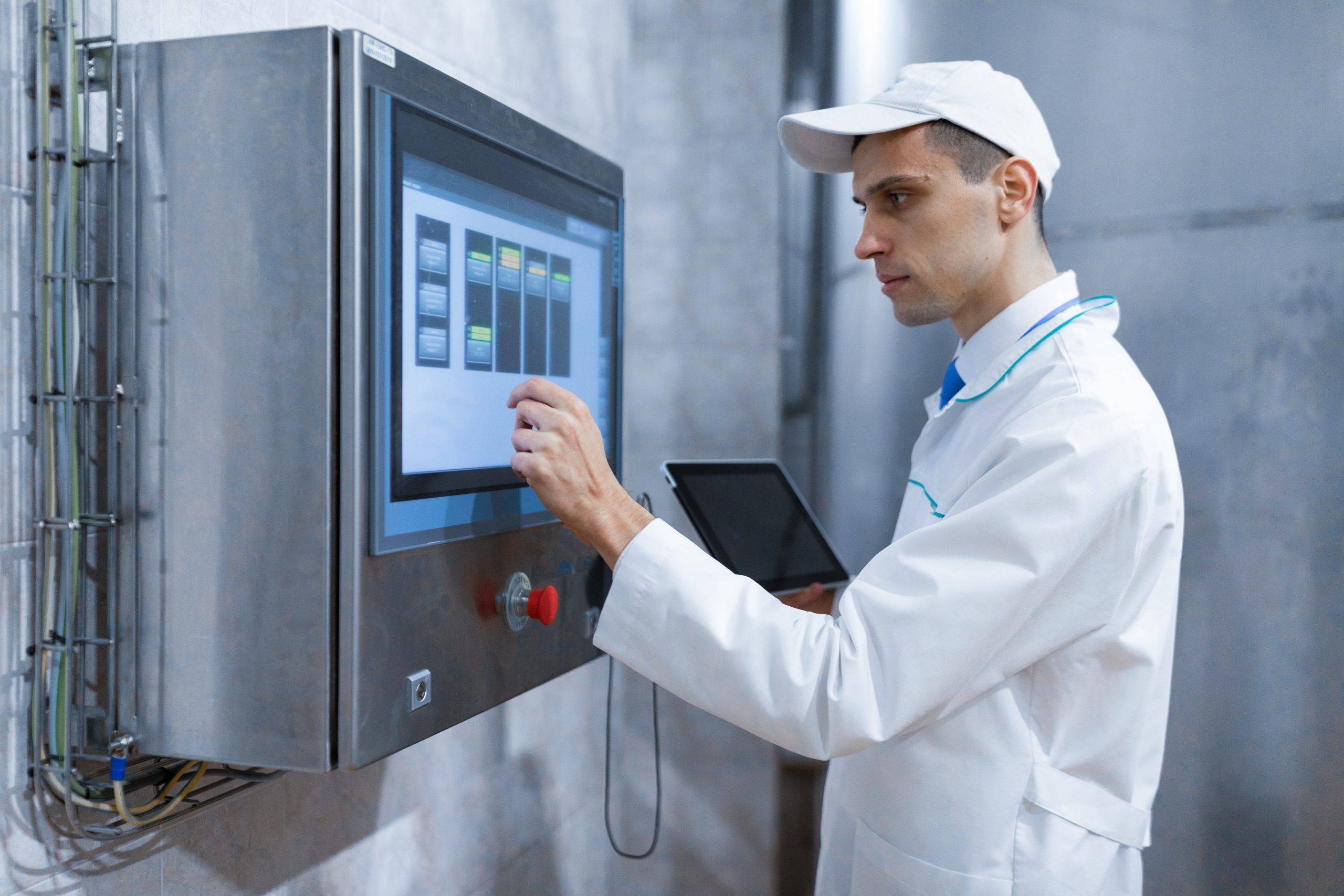 Technician monitoring industrial OT control panel in a global manufacturing facility
