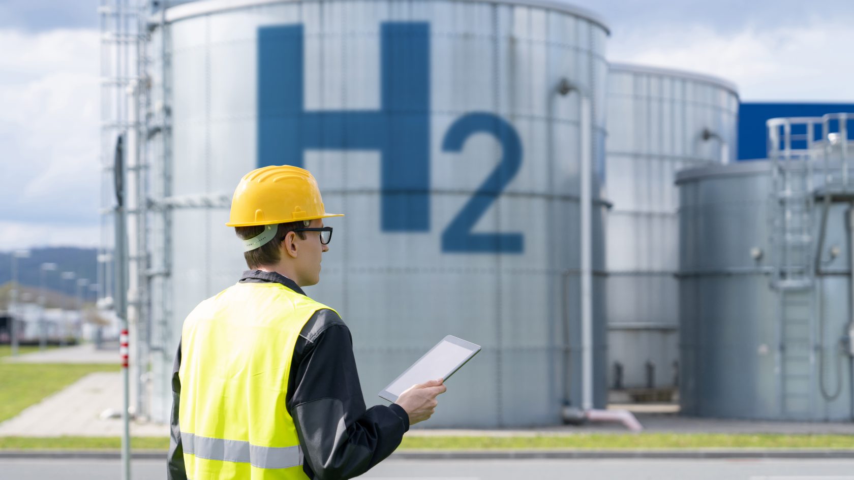 Industrial hydrogen storage tanks labeled H2 at a green hydrogen production facility