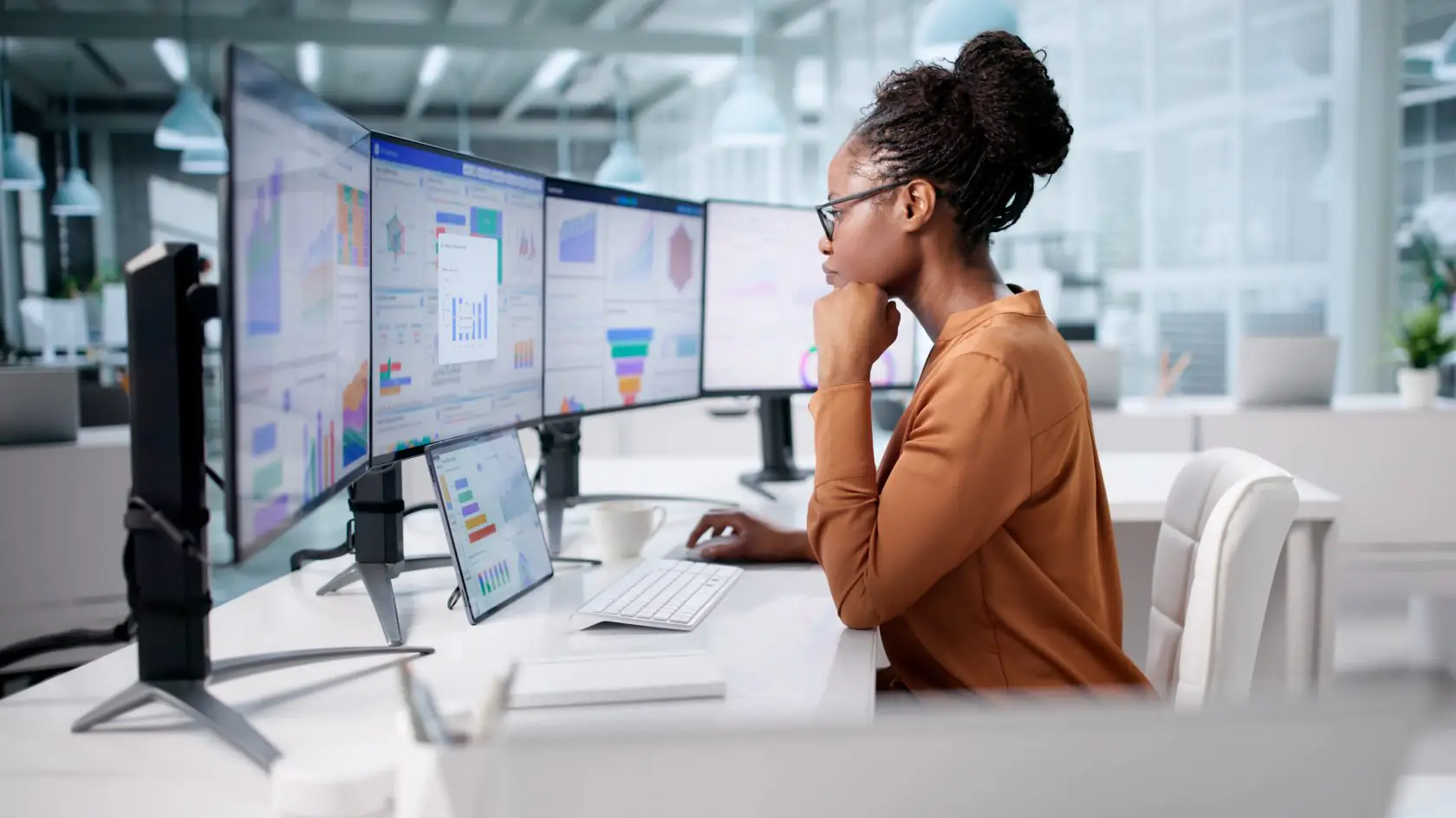 Business analyst reviewing enterprise planning dashboards across multiple monitors