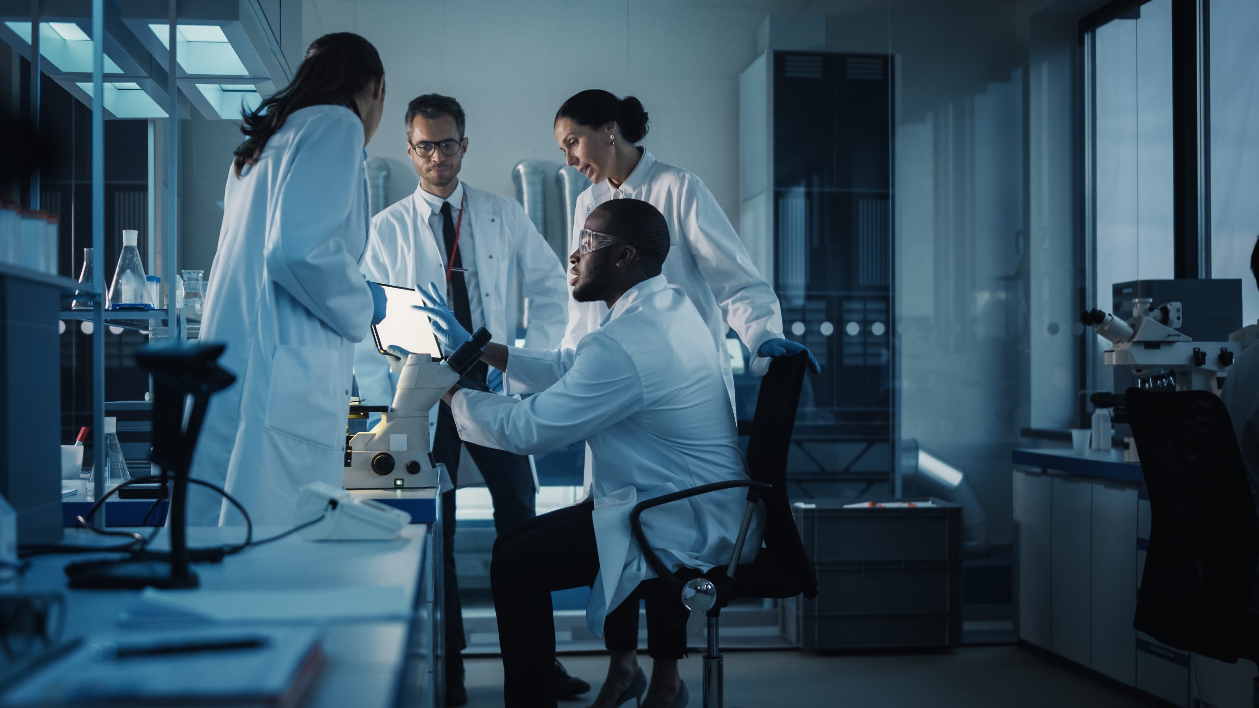 Healthcare professionals collaborating in a clinical setting while using digital tools and medical data.