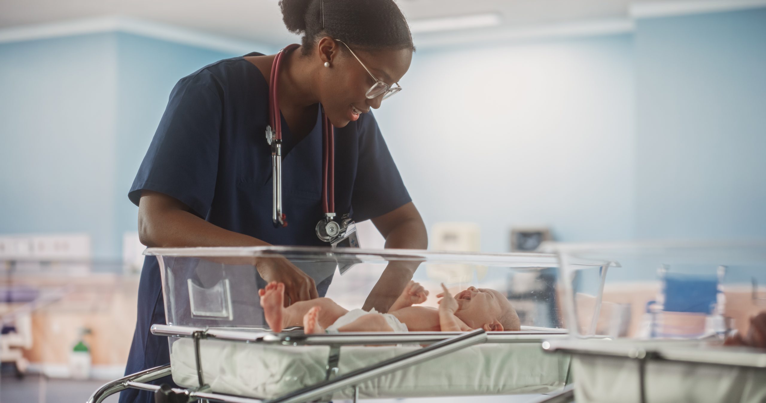 Healthcare professional caring for a newborn in a maternity ward