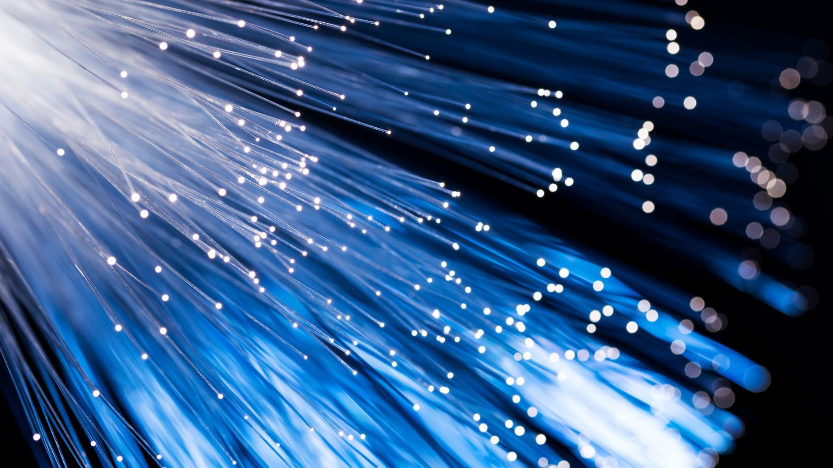 Close-up view of illuminated fiber optic cables representing high-speed telecom infrastructure