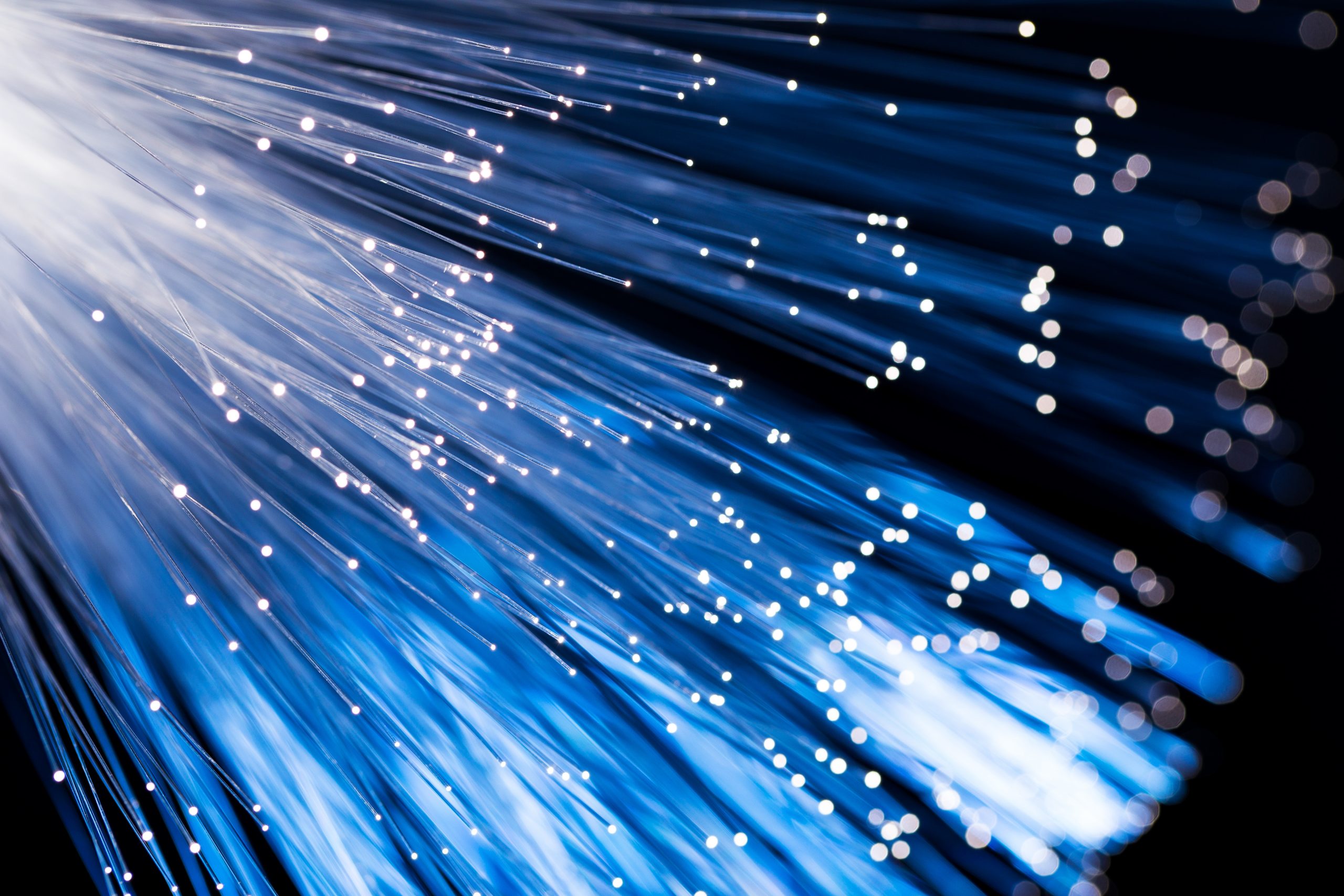 Close-up view of illuminated fiber optic cables representing high-speed telecom infrastructure
