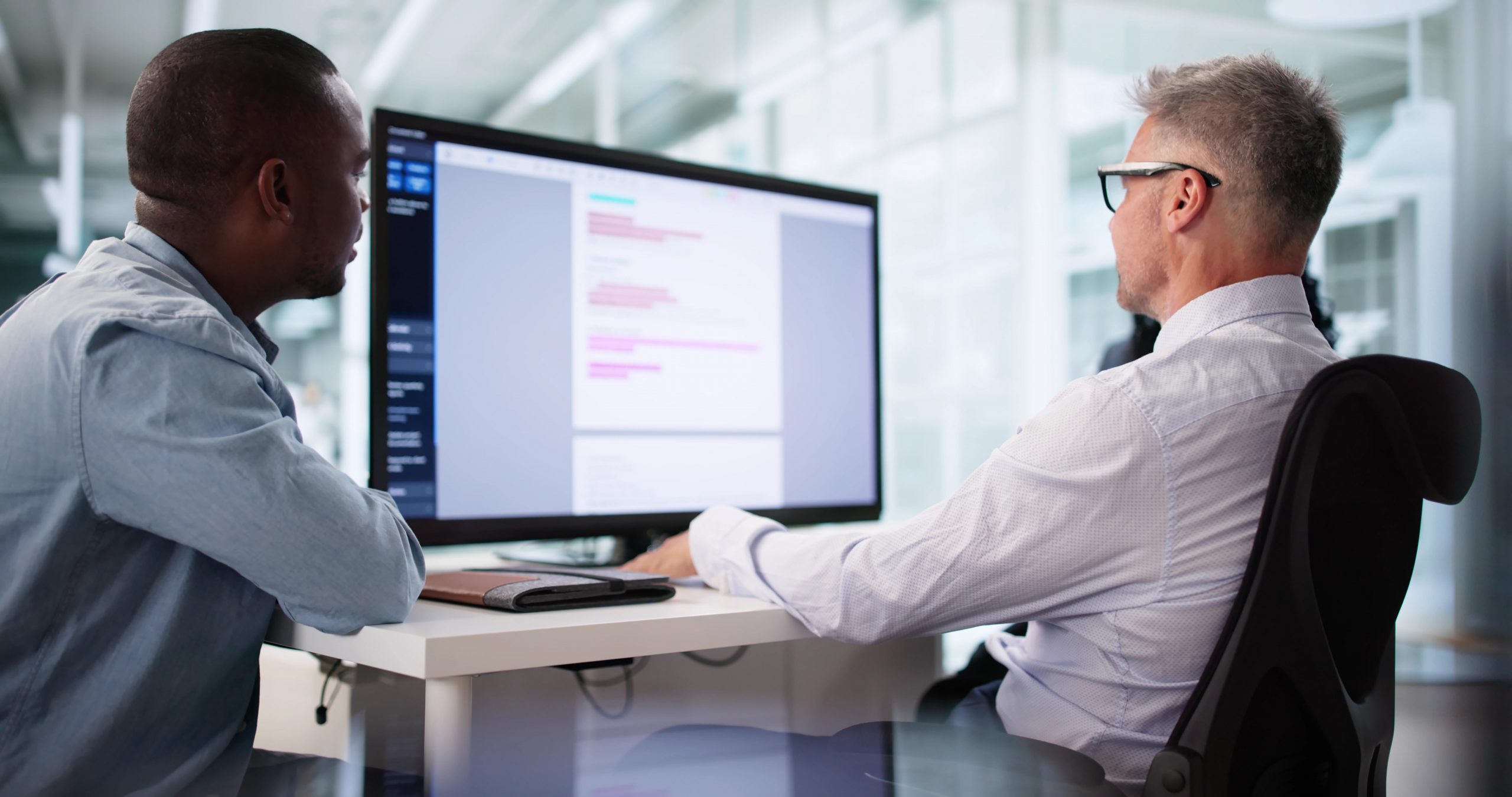 Two professionals reviewing a document on a computer screen as part of an intelligent document processing and automation workflow.