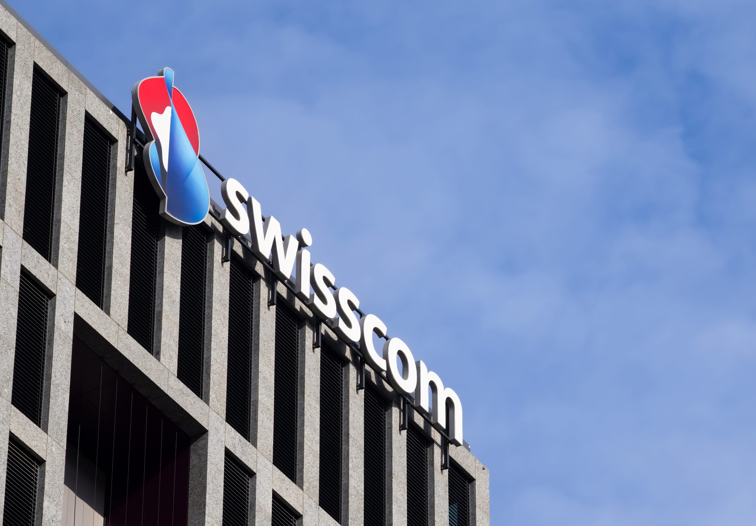 Swisscom office building displaying the company logo during Switzerland's nationwide fiber-to-the-home (FTTH) deployment programme