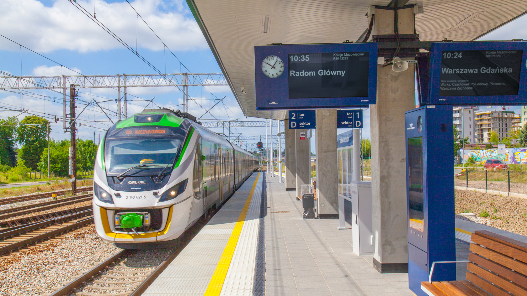 Dynamic passenger information displays and train arriving at Radom Wschód railway station in Poland