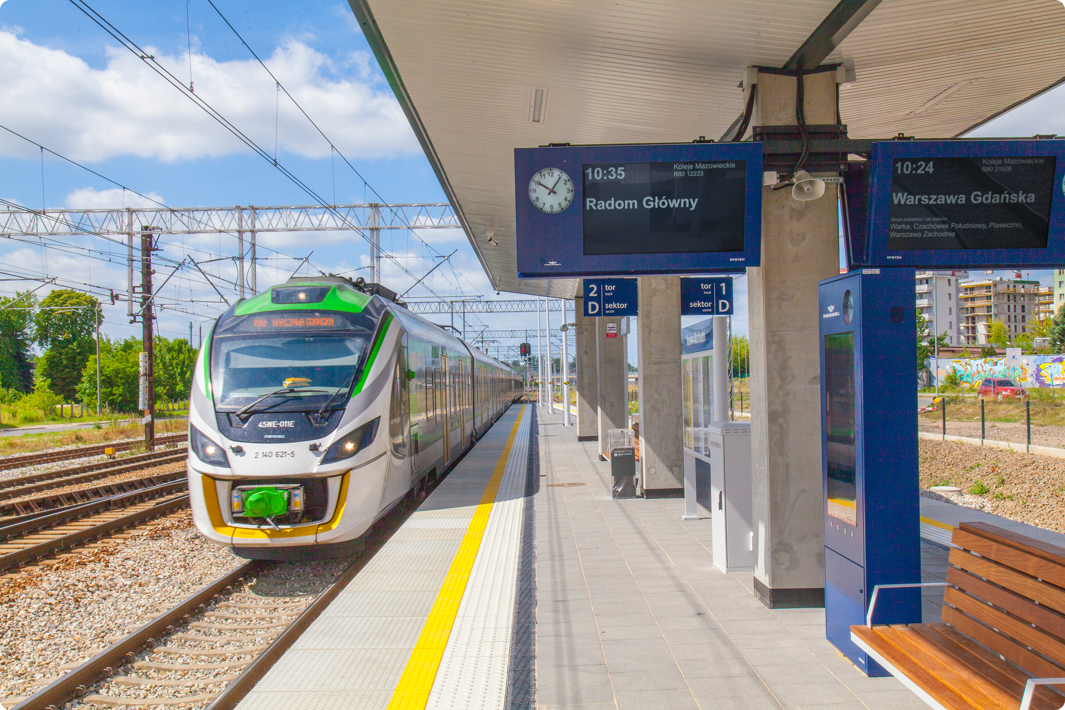 Dynamic passenger information displays and train arriving at Radom Wschód railway station in Poland
