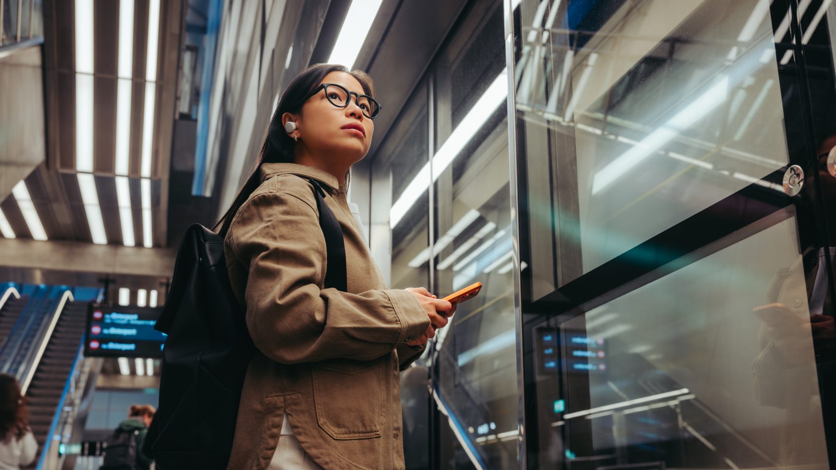 Passenger using a mobile device inside a modern metro station with secure connectivity supporting daily transport operations