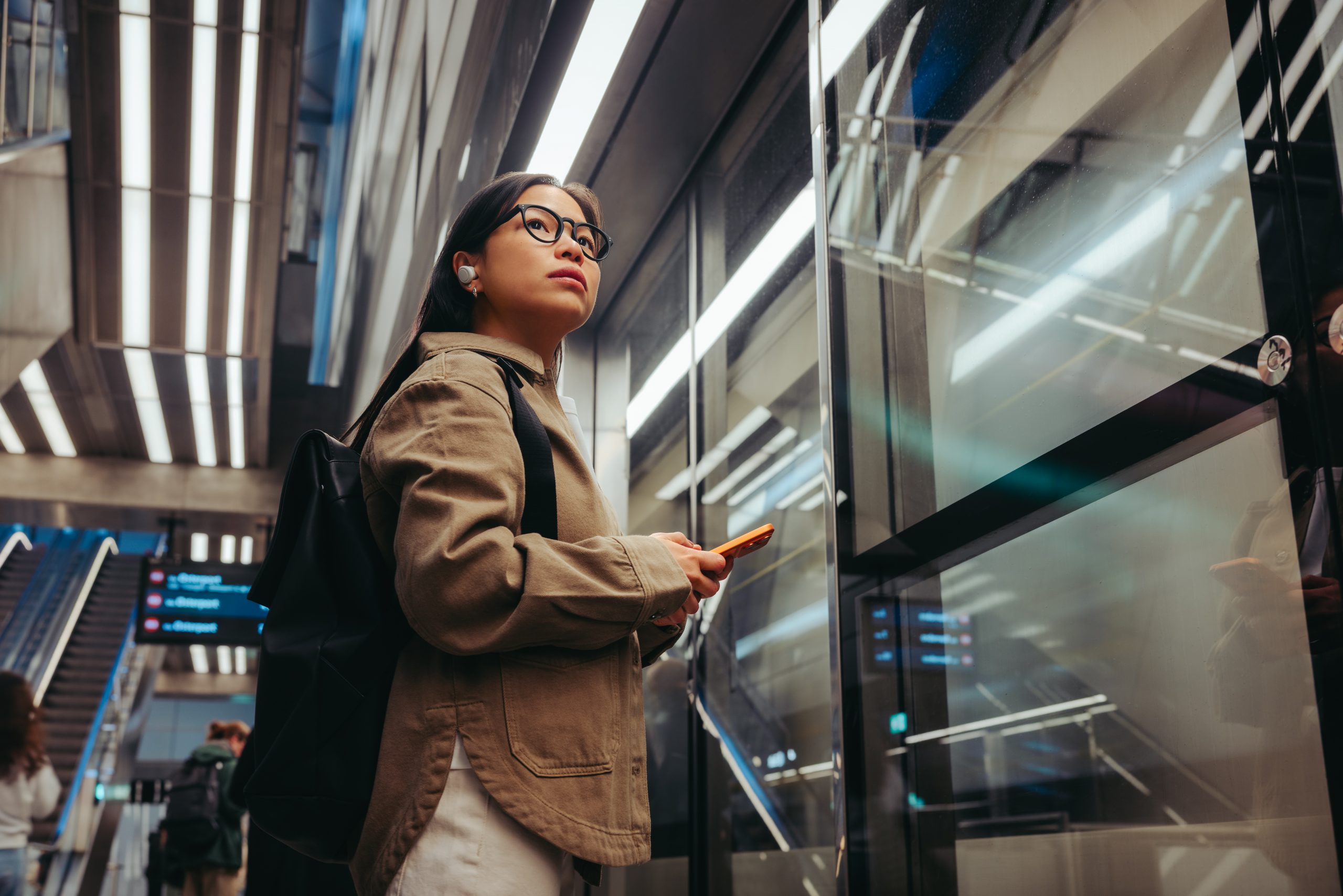 Passenger using a mobile device inside a modern metro station with secure connectivity supporting daily transport operations