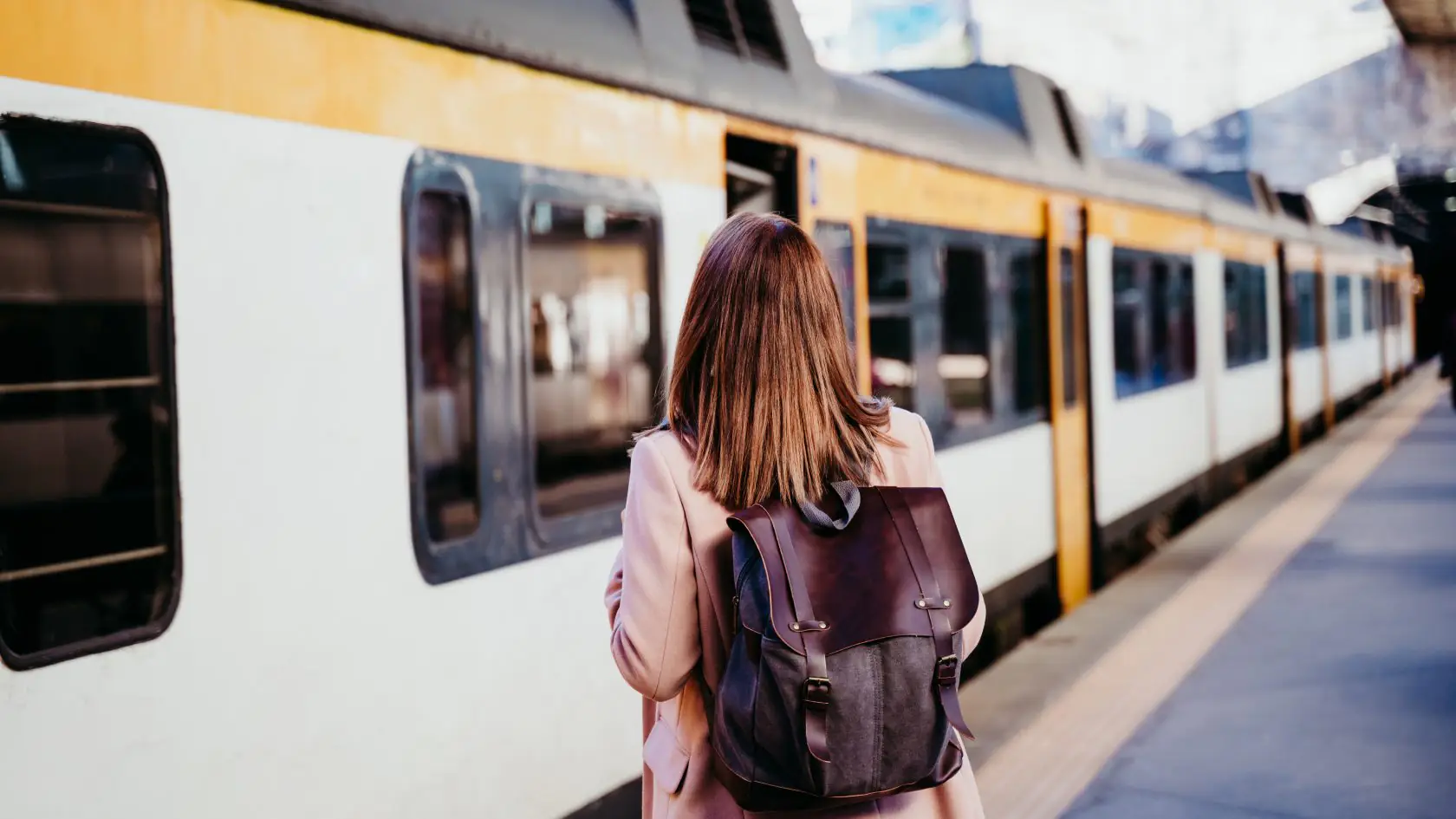 Person boarding a train at a railway platform, illustrating modern transport infrastructure and passenger mobility.