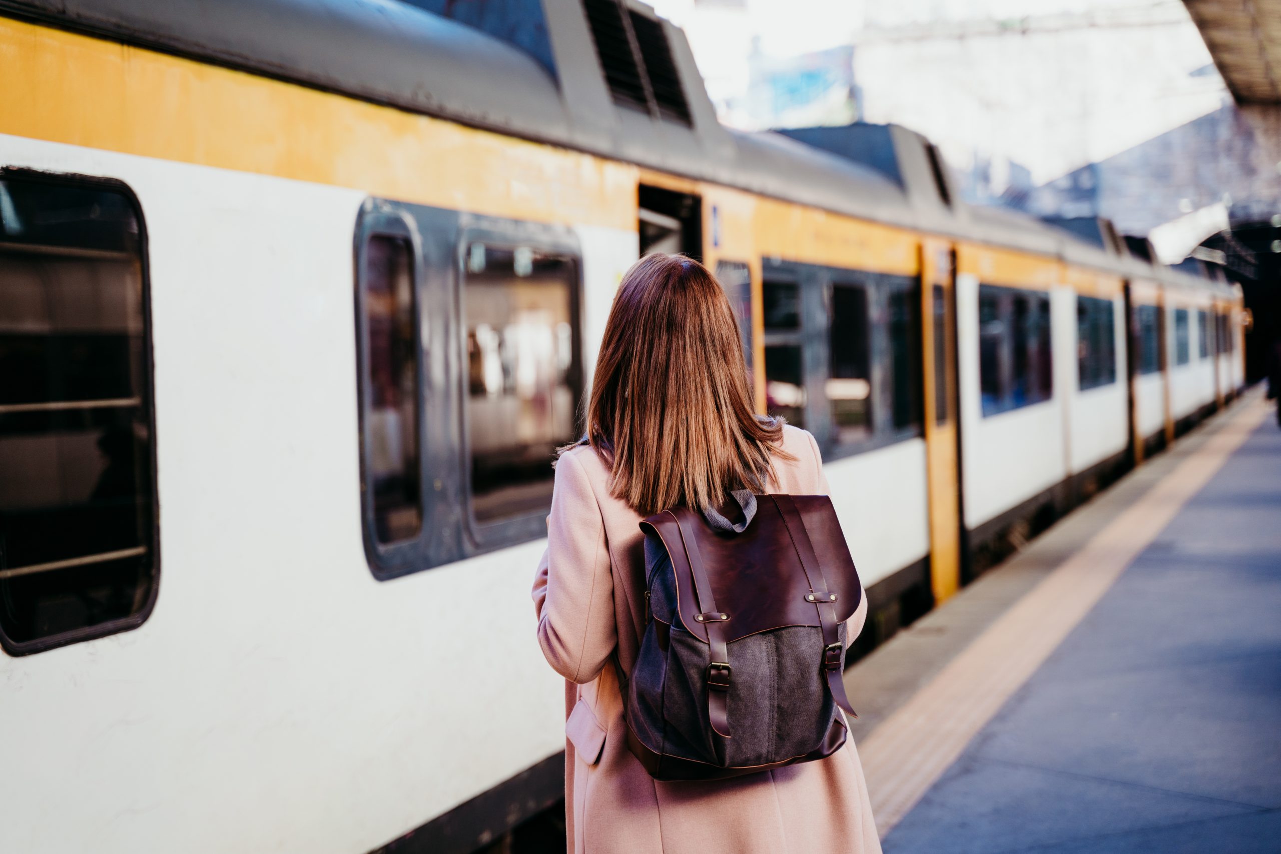 Person boarding a train at a railway platform, illustrating modern transport infrastructure and passenger mobility.